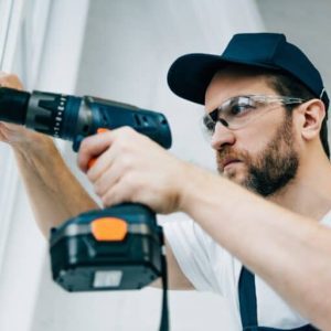 adult-repairman-in-goggles-fixing-window-handle-by-electric-drill-e1663969255653-768x513